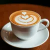 白のカップに入ったカフェラテ。葉をイメージしたラテアートが施されている。